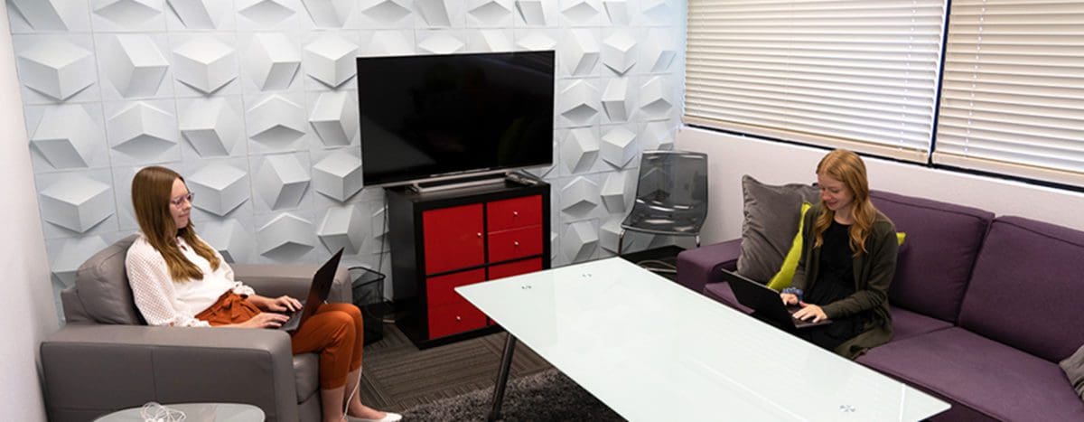 Two Envano employees working in the conference room named Cube.
