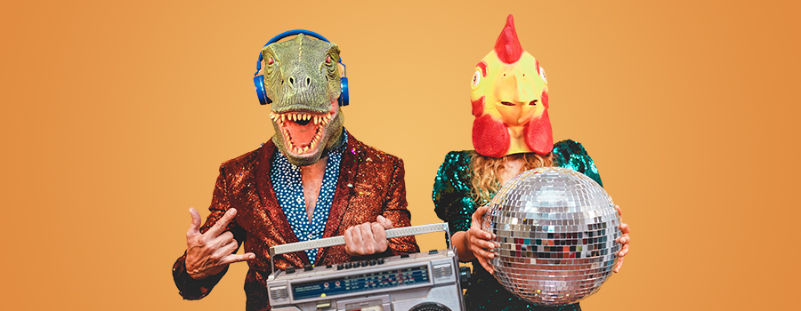 Two people in sparkly clothing. One is wearing a dinosaur head mask and the other a chicken head mask.